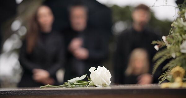 Rose, coffin and funeral at cemetery outdoor at burial